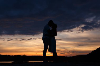 Couple standing holding hands at summer sunset