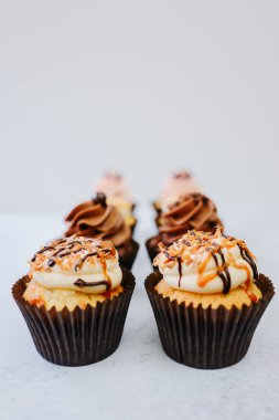 Custom cupcakes with thick frosting and caramel chocolate drizzle