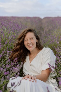 Woman sitting among the flowers in an English lavender field