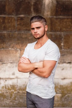 Young bearded blond man in a t-shirt on the street of the summer city