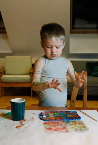 这个男孩在从事创造性工作 他用绘画来描绘自己的双手 — 图库照片