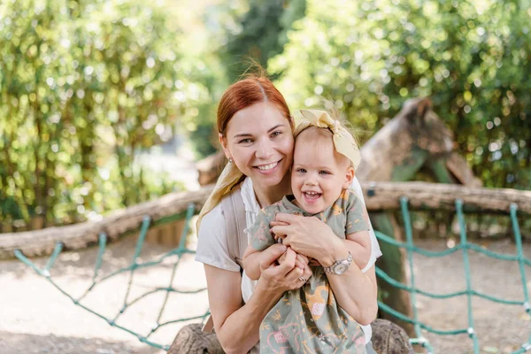 幸せなお母さんと幼児の女の子抱擁と笑いますザ遊び場 — ストック写真