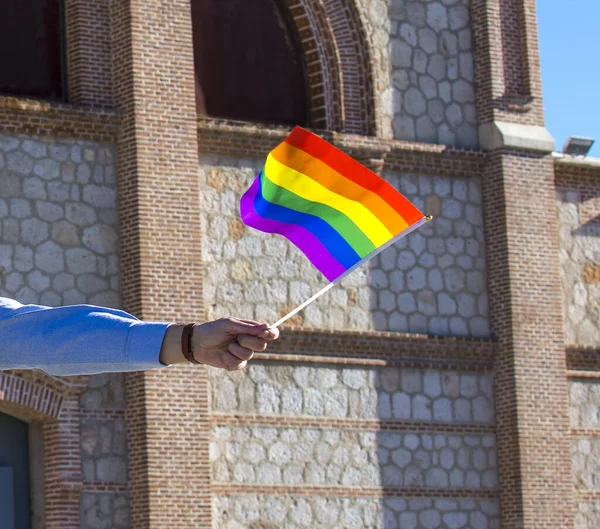 A man holding a rainbow flag