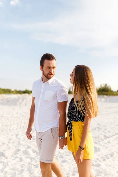 一个男人和一个女人在沙滩上手挽手散步 — 图库照片