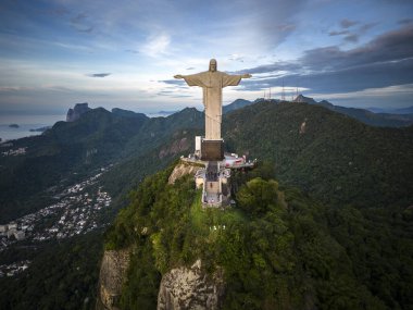 Rio de Janeiro, Brezilya 'da dağın tepesindeki Kurtarıcı İsa' ya güzel bir gün doğumu dronu manzarası 