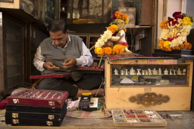 Mücevher pazarındaki bir kuyumcu Jodhpur 'un eski kasabasındaki küçük dükkanından alışveriş yapıyor.