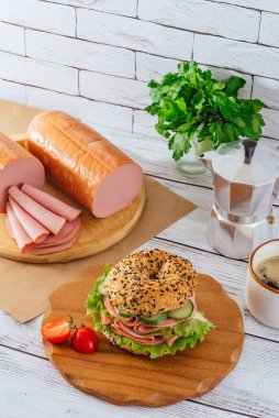 Jambonlu ve otlu simit. Jambon yakında. Kahve. Kahvaltı.