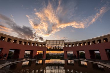 Brezilya, Paran 'ın başkenti Curitiba' daki Tangu Şehir Parkı binası ve su fıskiyelerine güzel gün batımı manzarası 