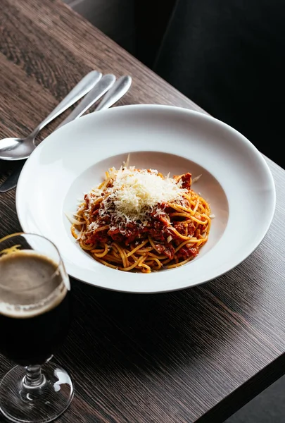 stock image pasta bolognese in a white plate on a dark table in a restaurant