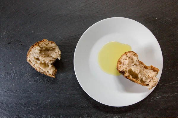 Хрустящий Хлеб Оливковое Масло Белой Тарелке Черной Доске — стоковое фото