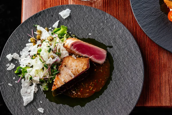 stock image grilled tuna steak with sauce in a plate on a wooden table