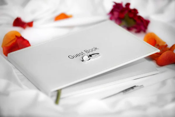 Kniha Svatebních Hostů Položená Bílém Hedvábí Obklopená Okvětními Lístky — Stock fotografie