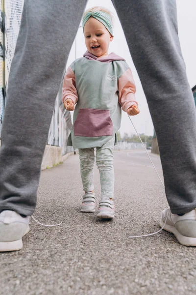 Kapüşonlu Bir Kız Çocuğu Babasının Ayakkabı Bağcıklarını Bağlıyor — Stok fotoğraf