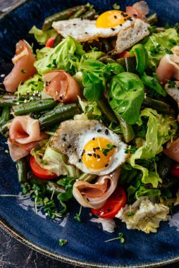 Bıldırcın yumurtalı salata, pastırma, sebze, bitki ve sos.