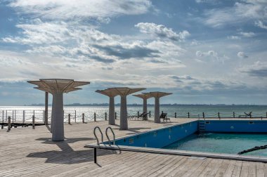 Odessa, Ukrayna 18.02.2023. Güneşli bir kış gününde Ukrayna 'nın Odessa kenti yakınlarındaki Fontanka köyünde Karadeniz kıyısında yüzme havuzu olan dinlenme alanı.