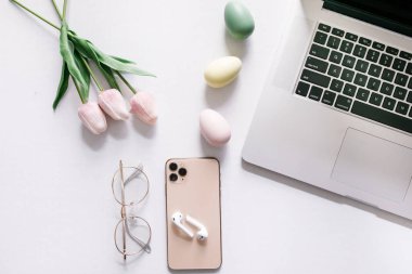 Bilgisayarlı telefon ve kulaklıklı renkli Paskalya yumurtaları.