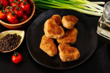 Siyah tabakta tavuk pirzolası. sebzeler ve bitkiler. siyah arkaplan