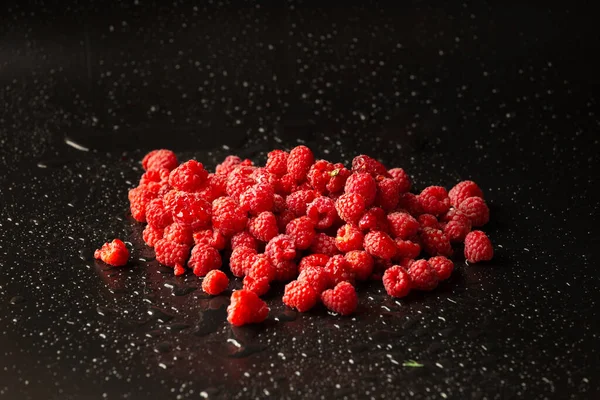 一座座红色的覆盆子 水滴在黑暗的背景下 有用的膳食产品 — 图库照片