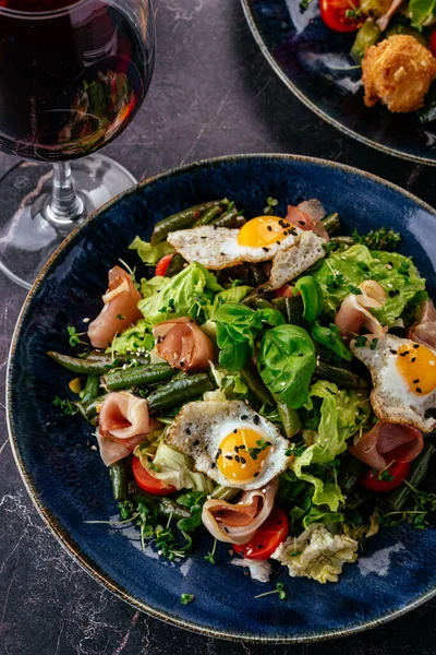 Bıldırcın yumurtalı salata, pastırma, sebze, bitki ve sos.