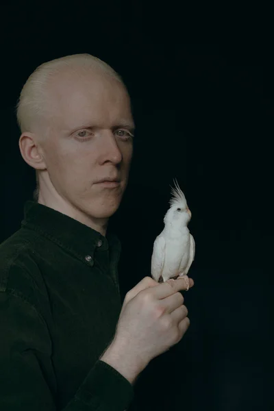一个白化病患者 有一只深色背景的白鹦鹉 — 图库照片