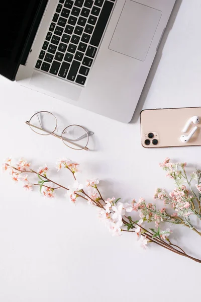 Biurko Otwartym Laptopem Telefonem Słuchawkami Wiosennymi Kwiatami — Zdjęcie stockowe