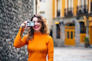 Sokakta fotoğraf çeken çekici genç bir kadın.