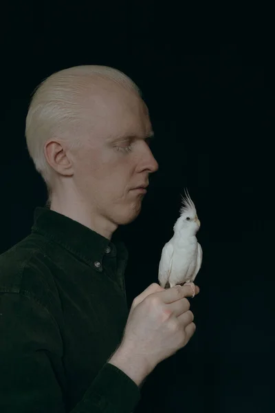 一个白化病患者 有一只深色背景的白鹦鹉 — 图库照片