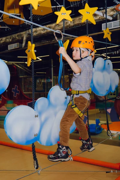 stock image boys of 6-7 years old climbing in adventure rope park indoors.