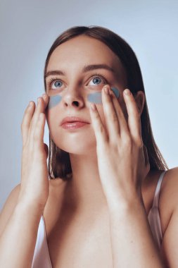 Güzel cilt. Sarışın kadın modelin kafa ve omuzları, parlayan, hidratlı cilt, toner, cilt kremi ya da losyonu sıhhatli görünüş için uygula, duş portresinden sonra, beyaz arka plan.
