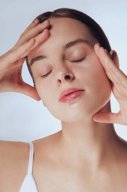 Güzel cilt. Sarışın kadın modelin kafa ve omuzları, parlayan, hidratlı cilt, toner, cilt kremi ya da losyonu sıhhatli görünüş için uygula, duş portresinden sonra, beyaz arka plan.
