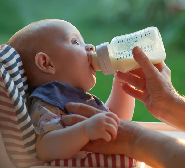 小さな子供が瓶から牛乳を飲む — ストック写真