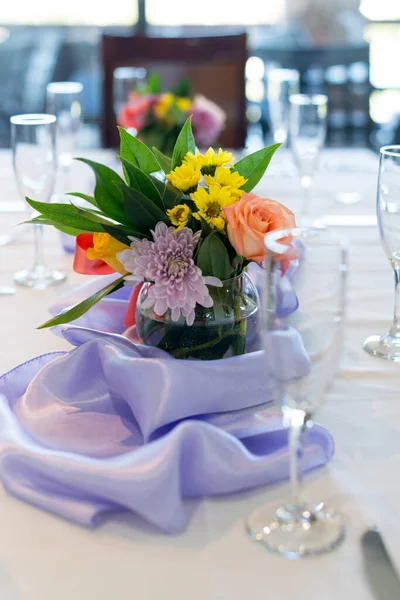 Floral centerpiece with purple table runner at large table