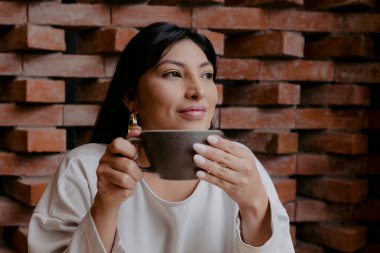 Tatlı İspanyol kadın elinde bir fincan kahve ve gülümsüyor.