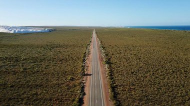 Gökyüzüne karşı düz bir Avustralya yolunun havadan görünüşü