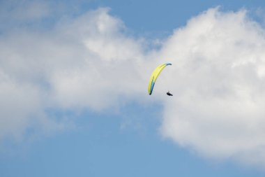 Paragliderler, BC 'nin sahil dağlarında güneşli bir günde gökyüzünde süzülürler..