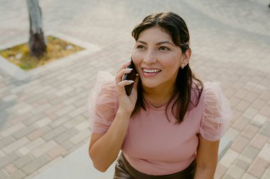 İspanyol kadın telefonda konuşuyor ve gülümsüyor.