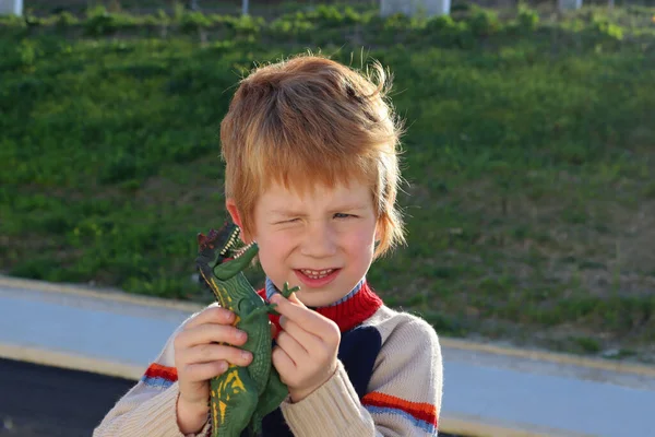 Ξανθό Αγόρι Κοίταξε Μάτια Του Και Παίζει Τον Δεινόσαυρο — Φωτογραφία Αρχείου