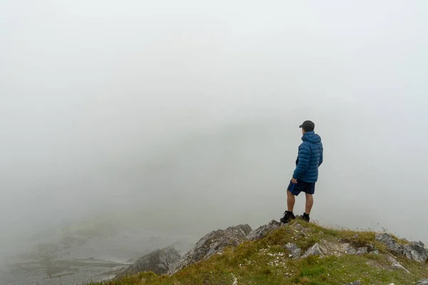 Man Standing Top Mountain Admiring Landscape Fog – stockfoto