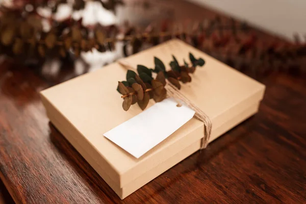 Prázdný Bílý Dárkový Poukaz Hnědou Dárkovou Krabičkou Provázkem Listy Eukalyptu — Stock fotografie