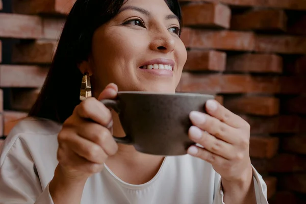 ヒスパニック系の女の子笑顔と保持コーヒーのカップ — ストック写真