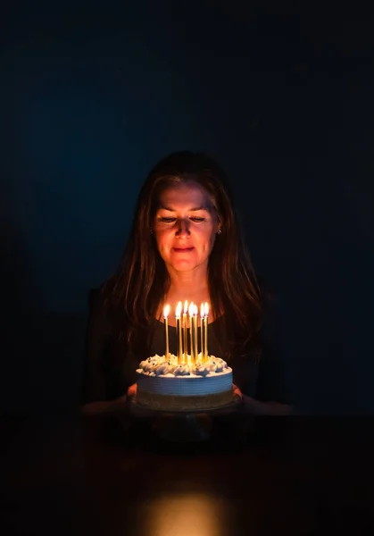 Mujer Atractiva Mirando Velas Pastel Cumpleaños Habitación Oscura —  Fotos de Stock