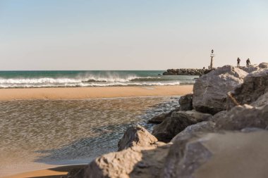Fransa 'nın güneyindeki sahilde kayalıklarda duran insanlar.