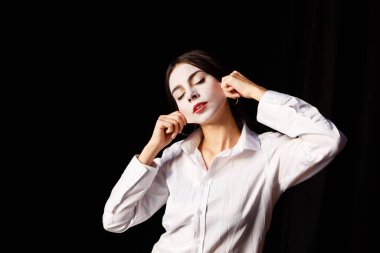 Prova salonunda beyaz makyajlı, kostümlü genç bir aktris.