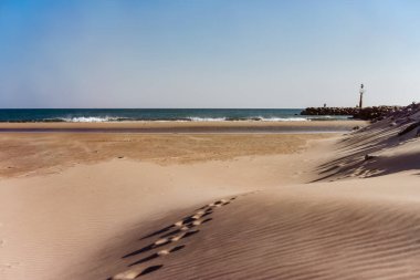 Kumlu sahilde Fransa 'nın kayalıklarına doğru giden ayak izleri.