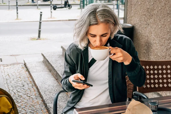 Woman Drinks Coffee Uses Phone Table Outdoor Cafe — Stock Photo, Image