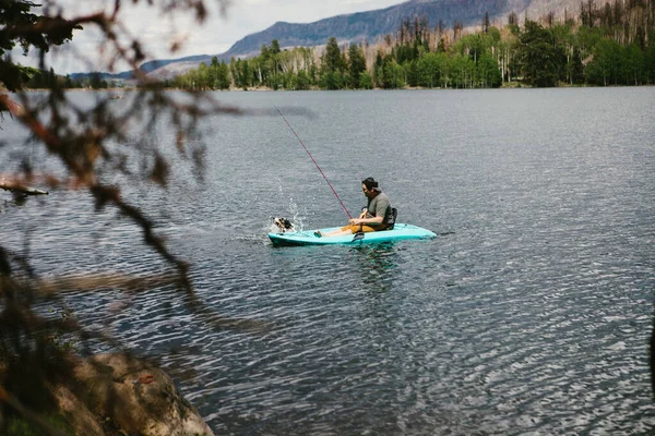 Bir Adam Köpekle Dağdaki Bir Gölde Kanoda Balık Tutuyor — Stok fotoğraf