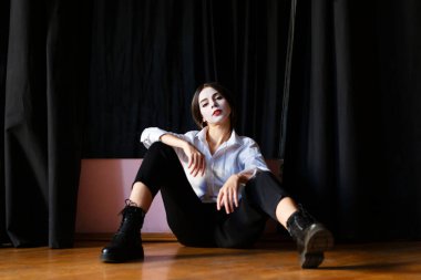 Prova salonunda beyaz makyajlı, kostümlü genç bir aktris.