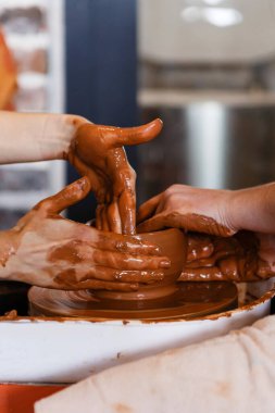 Çömlek çarkında kil biçiminde iki kadın.