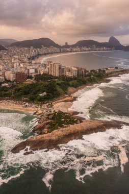 Arpoador 'daki okyanus kayalık noktasına güzel hava manzarası ve Ipanema, Rio de Janeiro, Brezilya' daki şehir binaları