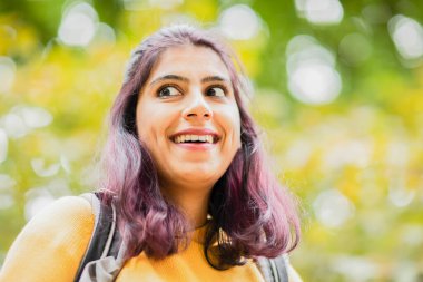 Genç kadın kameraya gülüyor. 